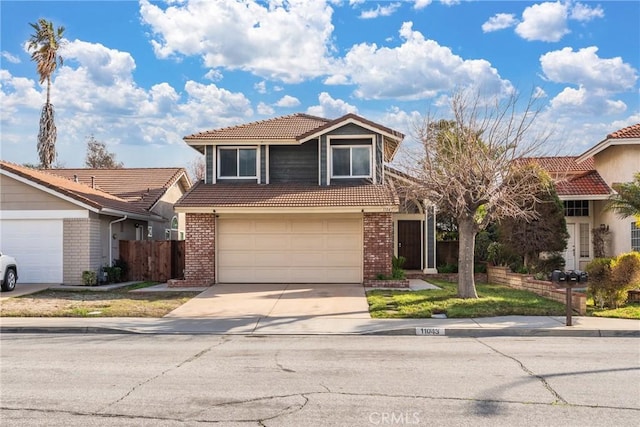 traditional home with driveway, brick siding, fence, and a tiled roof