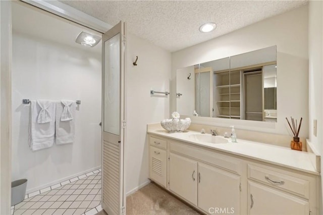 bathroom with baseboards, vanity, and a textured ceiling