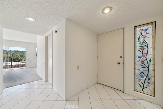 foyer with light tile patterned flooring and a textured ceiling
