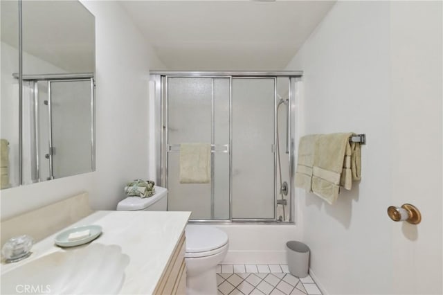 bathroom featuring toilet, tile patterned floors, bath / shower combo with glass door, and vanity