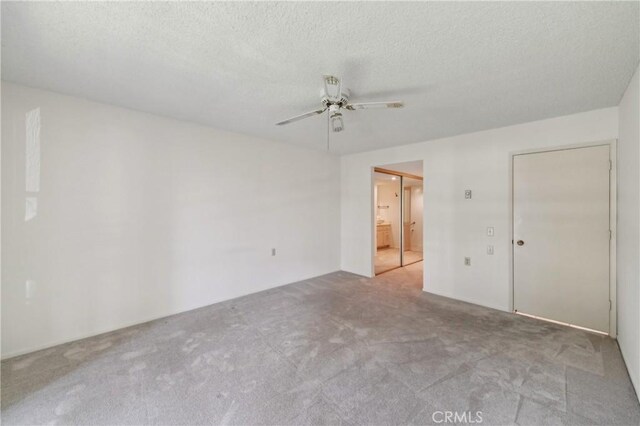 unfurnished bedroom featuring carpet floors, a textured ceiling, ceiling fan, and connected bathroom