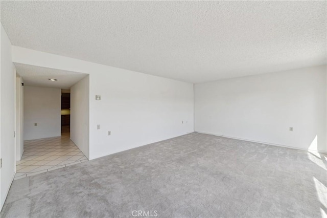 unfurnished room featuring light carpet and a textured ceiling
