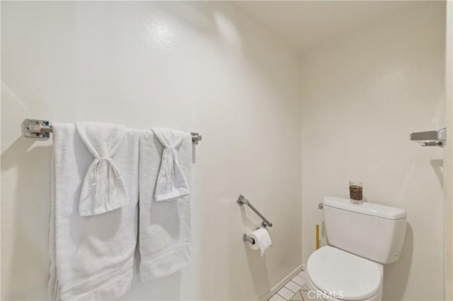 bathroom featuring toilet, tile patterned floors, and baseboards