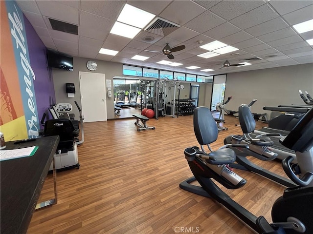 gym with visible vents, a paneled ceiling, and wood finished floors