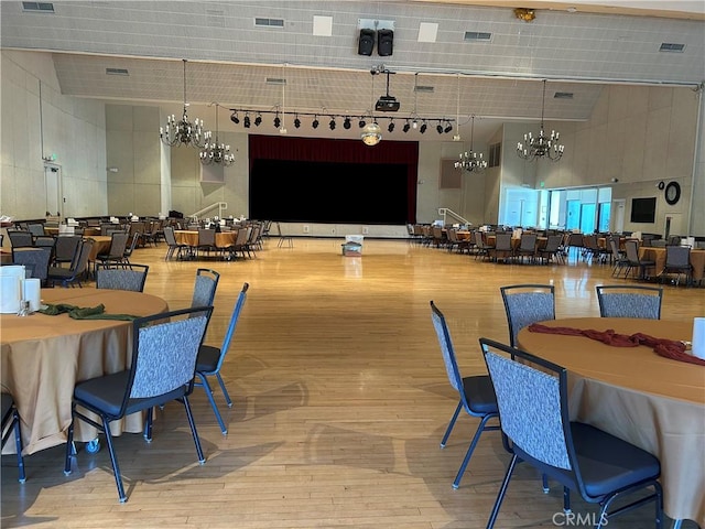 dining space featuring visible vents, a towering ceiling, and an inviting chandelier