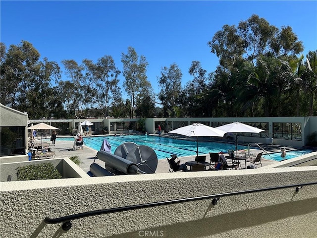 community pool with fence and a patio