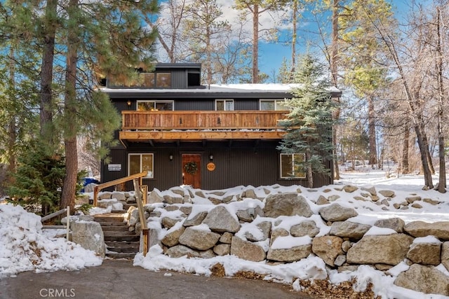 snow covered property with a wooden deck