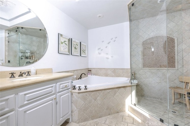 bathroom with a stall shower, a bath, and vanity