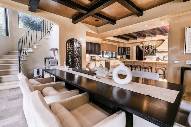 interior space featuring beam ceiling, stone tile flooring, a chandelier, coffered ceiling, and stairs