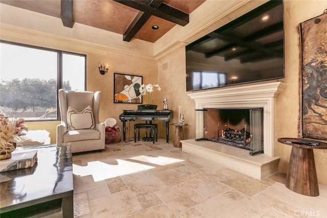 living room featuring stone tile flooring, beam ceiling, and a high end fireplace