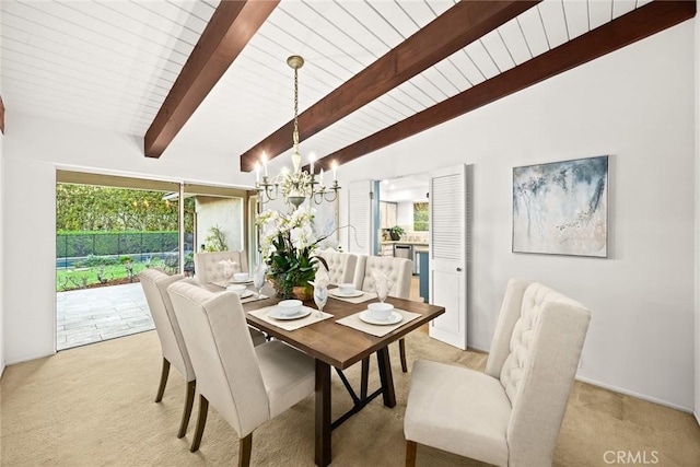 dining area with a wealth of natural light, light colored carpet, lofted ceiling with beams, and an inviting chandelier