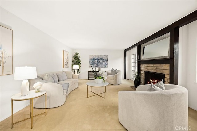 carpeted living area featuring a stone fireplace