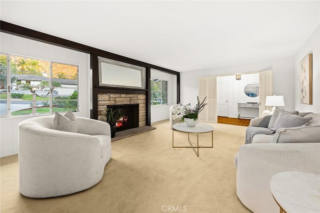 living room with light colored carpet and a stone fireplace