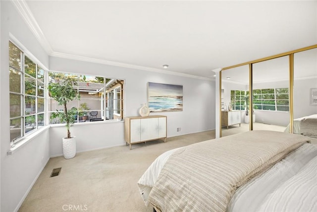 bedroom featuring baseboards, visible vents, light colored carpet, crown molding, and a closet