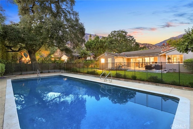 view of swimming pool featuring a mountain view, fence, and a fenced in pool