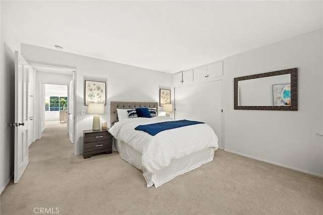 bedroom with light carpet and baseboards