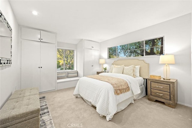 bedroom featuring two closets and light colored carpet