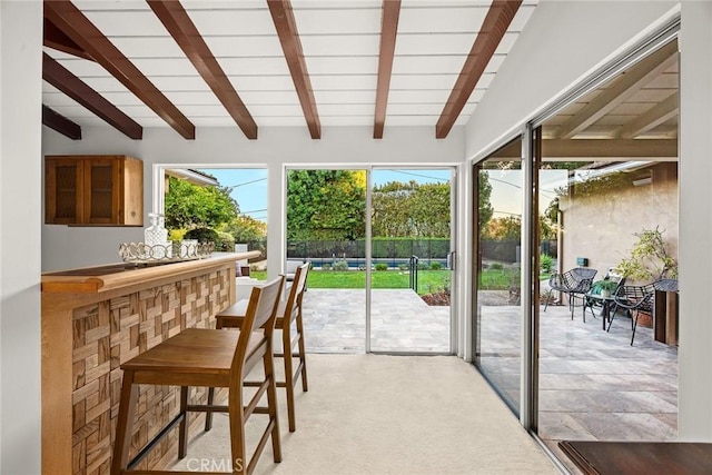 entryway featuring light carpet and lofted ceiling with beams