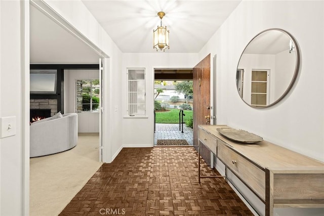 entryway with a healthy amount of sunlight, baseboards, and a stone fireplace