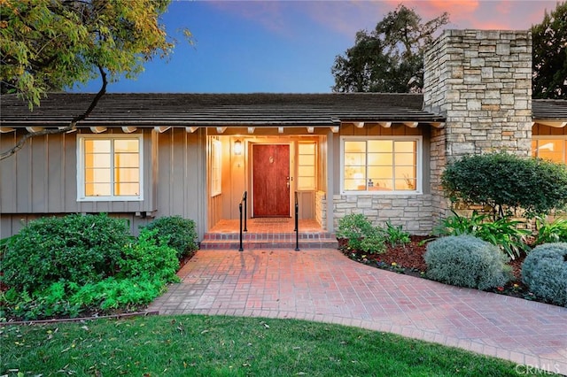 doorway to property with stone siding and board and batten siding