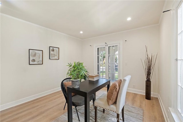 dining space with light wood-style flooring, baseboards, and crown molding