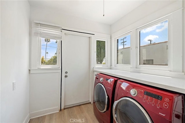 laundry area with light wood-type flooring, washer and dryer, laundry area, and baseboards