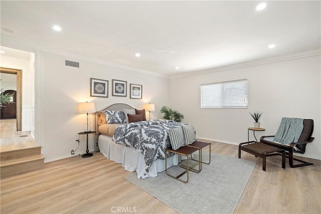 bedroom with light wood-style flooring, visible vents, crown molding, and recessed lighting