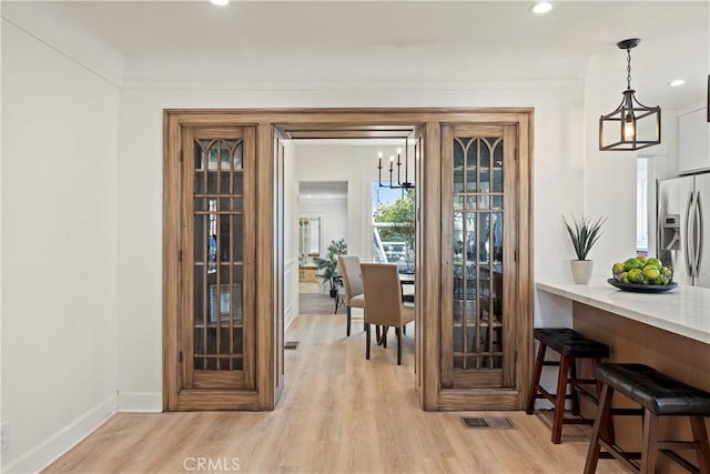 doorway with recessed lighting, light wood-type flooring, visible vents, and baseboards