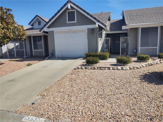 ranch-style house with driveway, a tiled roof, an attached garage, and stucco siding