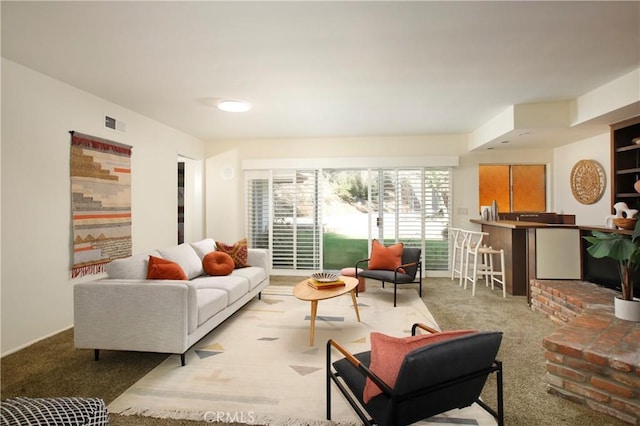 living area with visible vents and light colored carpet