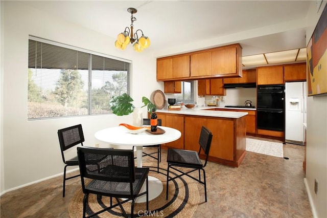 kitchen with dobule oven black, a peninsula, gas stovetop, light countertops, and decorative light fixtures