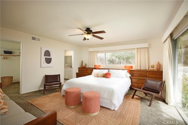 bedroom with carpet floors, a closet, visible vents, a spacious closet, and ceiling fan