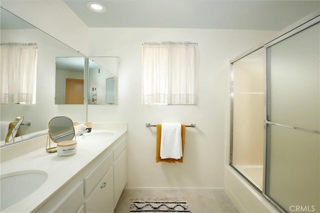 bathroom with enclosed tub / shower combo, double vanity, a sink, and recessed lighting