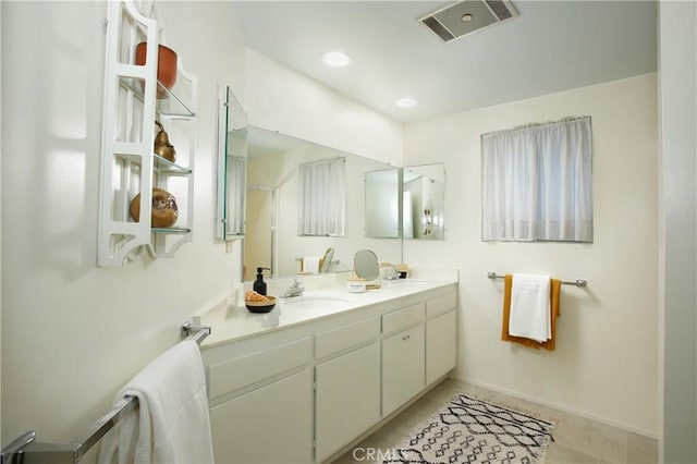 full bath featuring double vanity, tile patterned flooring, visible vents, and a sink