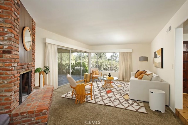 living room featuring visible vents, a fireplace, and carpet flooring