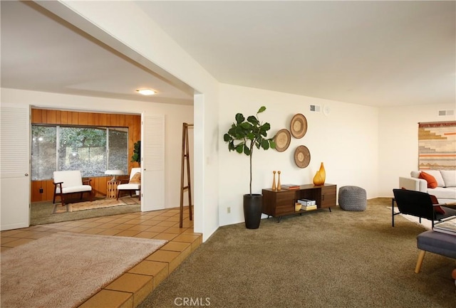 sitting room with light tile patterned floors, visible vents, and light colored carpet