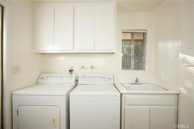 washroom featuring cabinet space, separate washer and dryer, and a sink