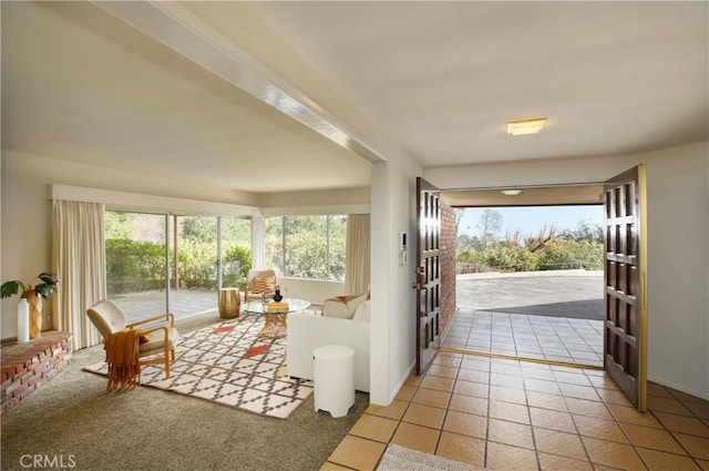 doorway with light tile patterned floors, plenty of natural light, and light colored carpet