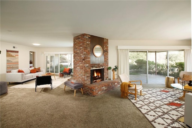 living room with a brick fireplace and carpet floors