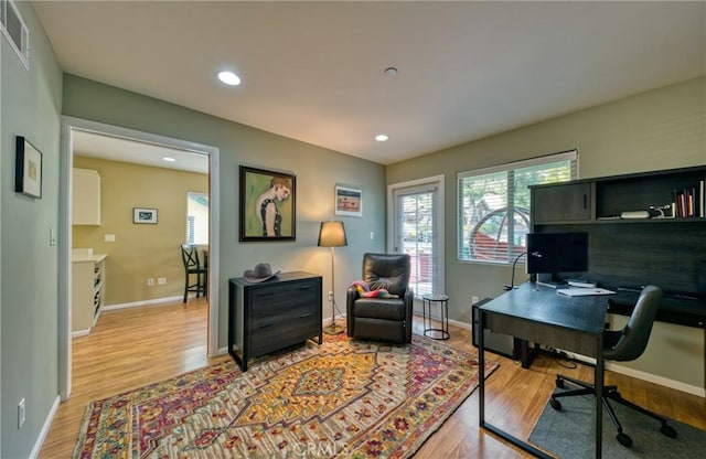 office with light wood-style floors, visible vents, baseboards, and recessed lighting