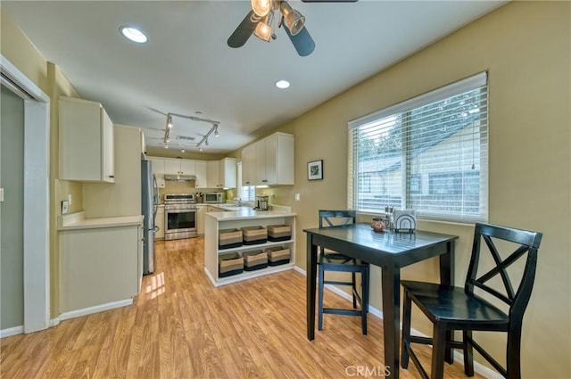 kitchen with stainless steel appliances, recessed lighting, light wood-style floors, white cabinets, and a sink