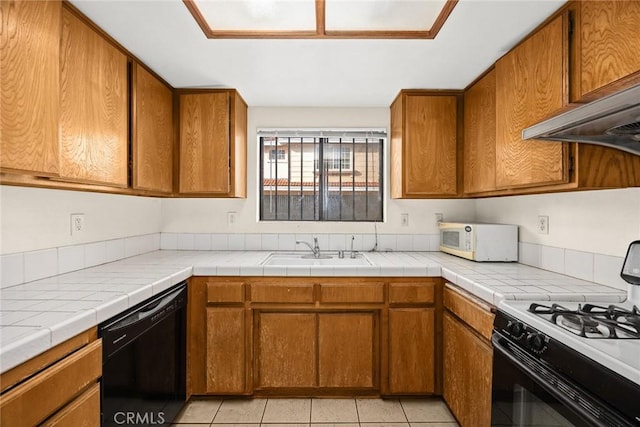 kitchen with brown cabinets, gas range oven, white microwave, a sink, and dishwasher