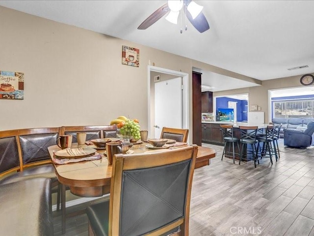 dining room featuring visible vents, a ceiling fan, and wood finished floors