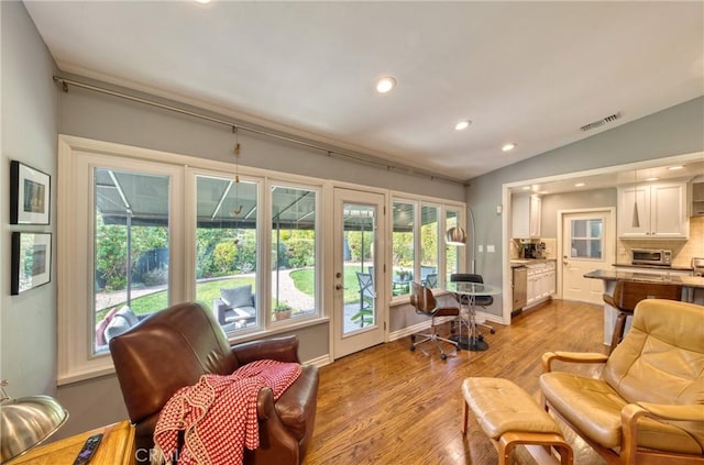 sitting room with baseboards, visible vents, vaulted ceiling, light wood-style floors, and recessed lighting