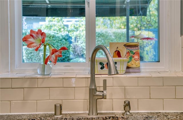 room details featuring light stone counters and a sink