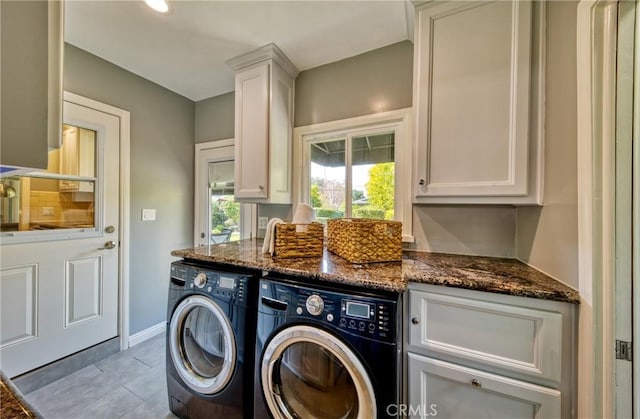 laundry room with cabinet space, baseboards, and washer and clothes dryer