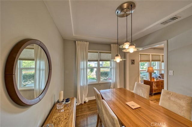 dining space with visible vents, dark wood-type flooring, and a wealth of natural light