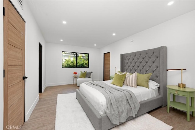 bedroom with light wood-style flooring, baseboards, and recessed lighting