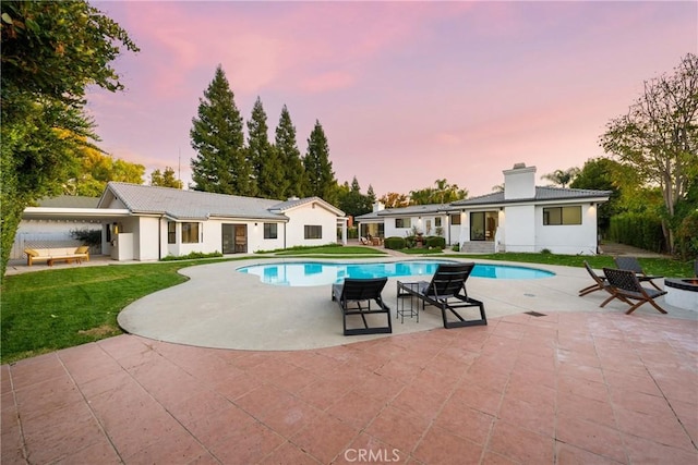 pool featuring a patio area and a lawn