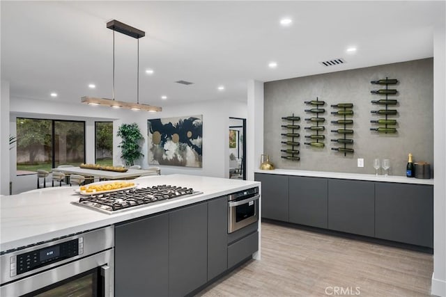 kitchen featuring stainless steel appliances, light countertops, visible vents, and gray cabinetry